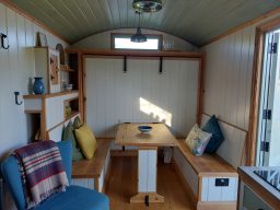 Cozy interior of a tiny home featuring a dining table and decorative cushions.