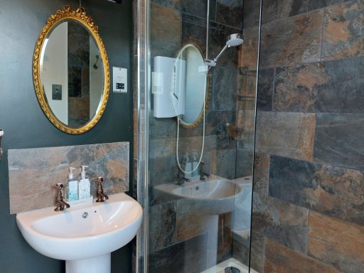 Modern bathroom featuring a basin, large mirror, and tiled walls.